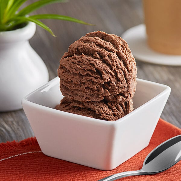 A bowl of chocolate ice cream with a spoon in it.