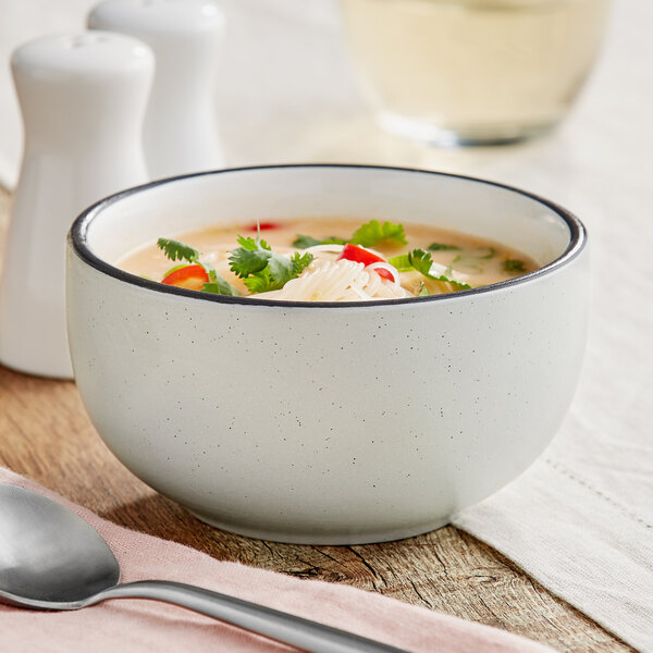 An Acopa Embers stoneware bowl filled with soup with noodles and cilantro.