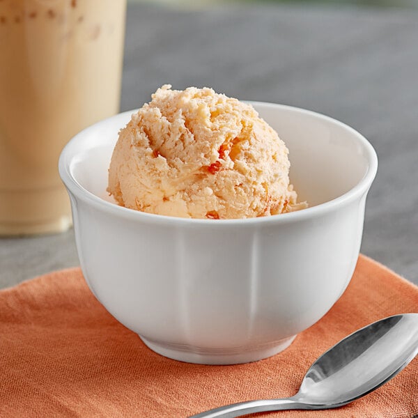 A bowl of Oringer Orange Pineapple hard serve ice cream with a spoon.