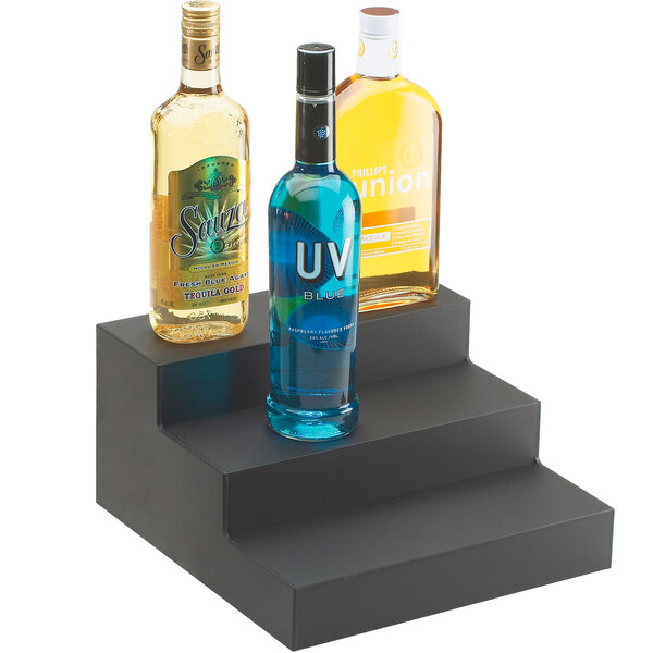 A black Cal-Mil bottle display holding three bottles of alcohol.