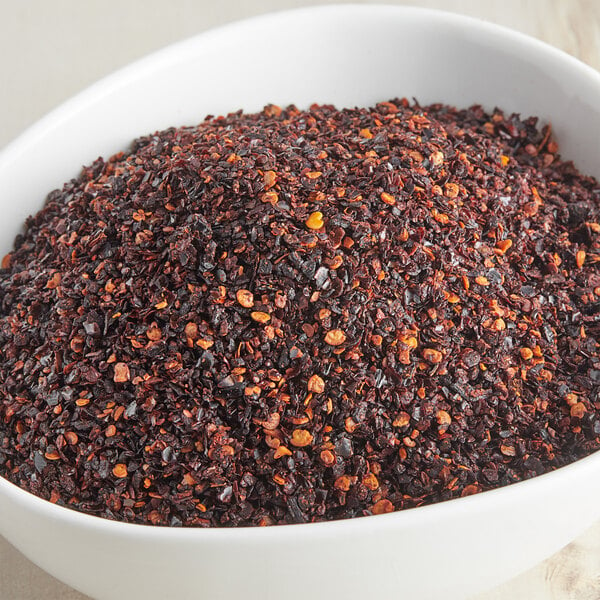 A bowl of McCormick Culinary Crushed Chipotle Pepper. Red and black flakes in a bowl.
