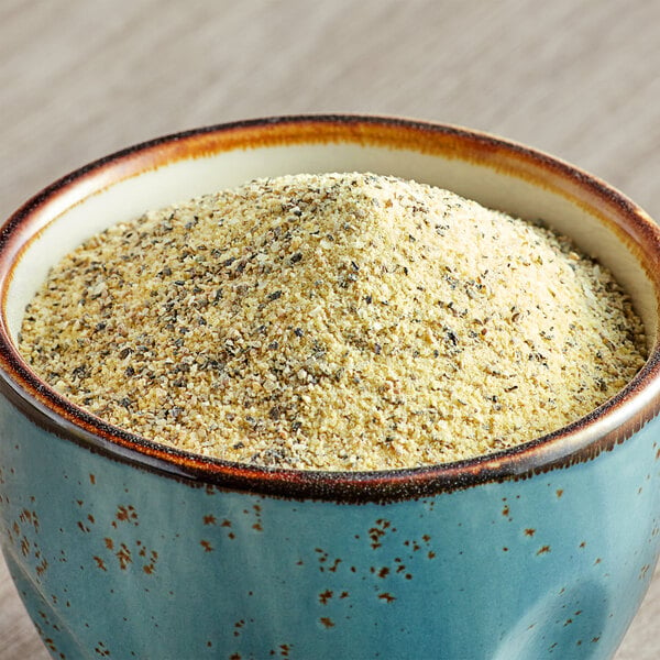 A bowl of McCormick Culinary Lemon and Pepper seasoning salt on a table.