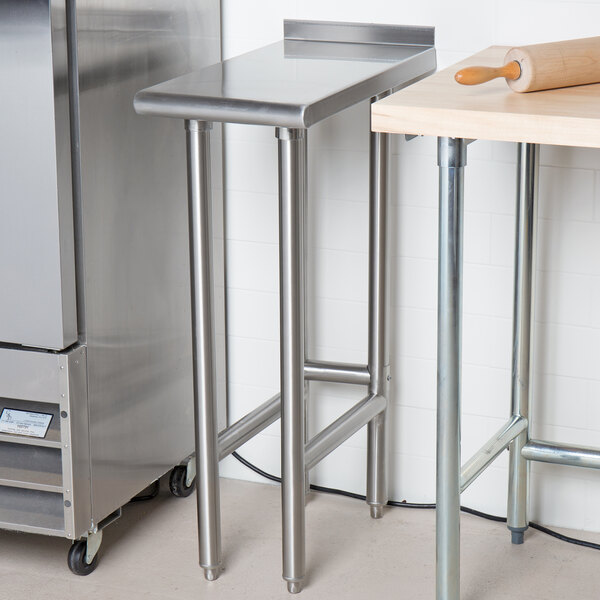 A stainless steel Advance Tabco filler table with a rolling pin on it.