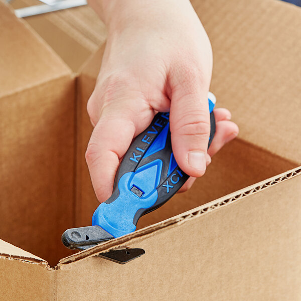 A hand holding a blue Klever Kutter X-Change box cutter