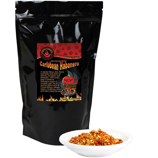 A black bag of Fiery Farms red Caribbean habanero pepper flakes with a red label next to a bowl of crushed red pepper.
