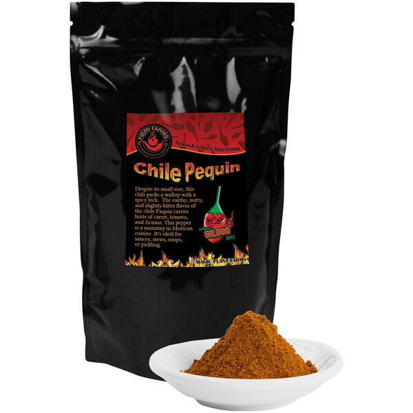 A black bag of Fiery Farms Chili Pequin Pepper Powder on a table with a bowl of brown powder.