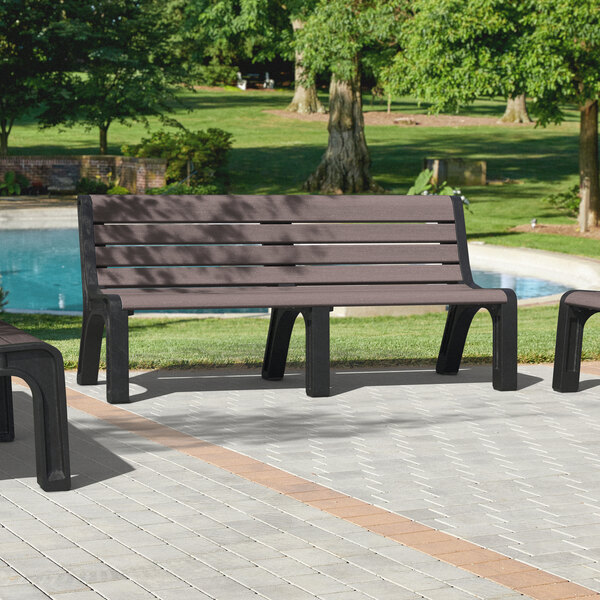 A group of brown MasonWays Malibu-style benches with black legs sitting in front of a pool.