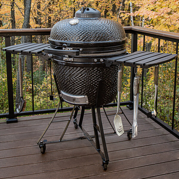 A round black Louisiana Grills K24 ceramic grill on a deck.