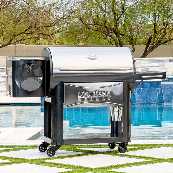 A Louisiana Grills Founders Legacy 1200 pellet grill on a table outdoors.