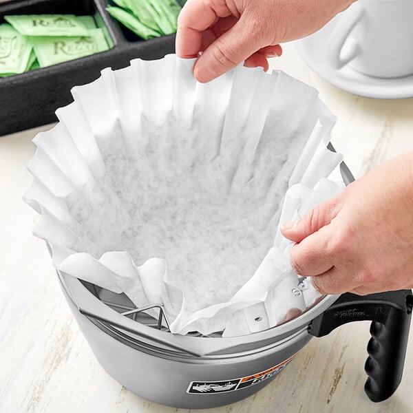 A person's hands using a Choice coffee filter to make coffee.