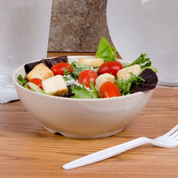 A bowl of salad with tomatoes and croutons in a GET BamboMel bowl.