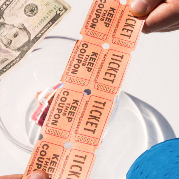 A person holding Carnival King orange raffle tickets.