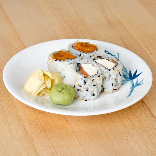 A Thunder Group Blue Bamboo melamine plate with sushi on a wood table.