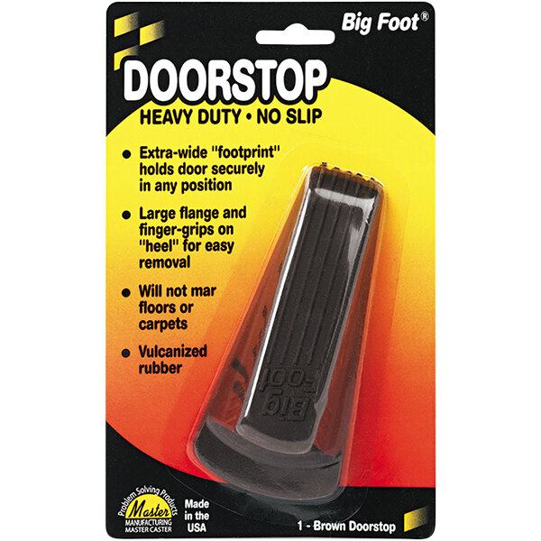 A brown rubber door stopper with a no slip pad on the bottom in a package.