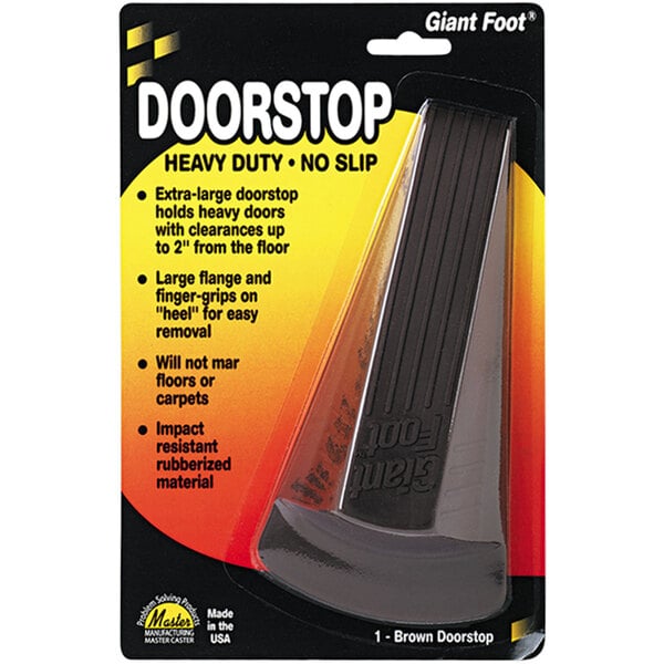 A black Master Caster Giant Foot rubber door stopper in a black and yellow package.