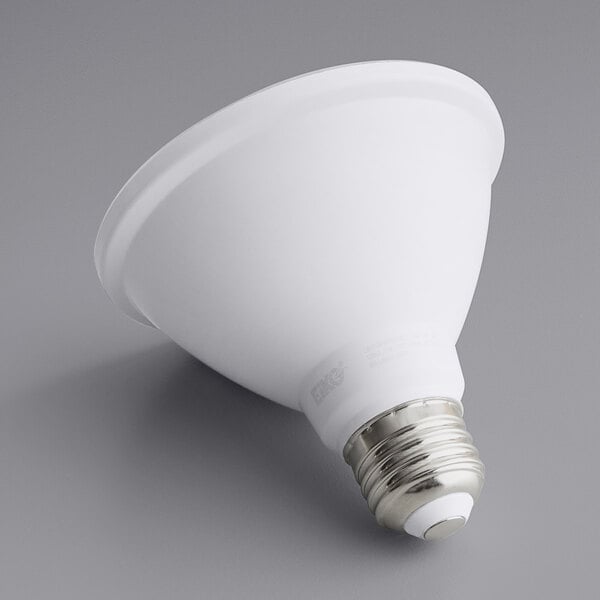 An Eiko 11 watt dimmable flood LED light bulb with a silver base on a gray surface.