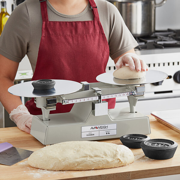 A person in a red apron weighing dough on an AvaWeigh baker's dough scale.