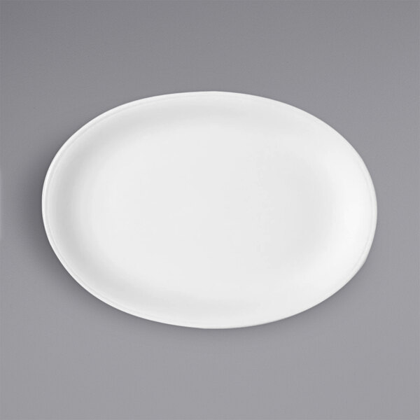A Bauscher bright white oval porcelain coupe platter on a gray surface.