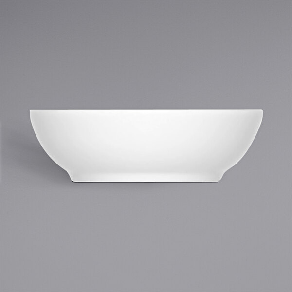 A Bauscher bright white porcelain bowl on a gray background.