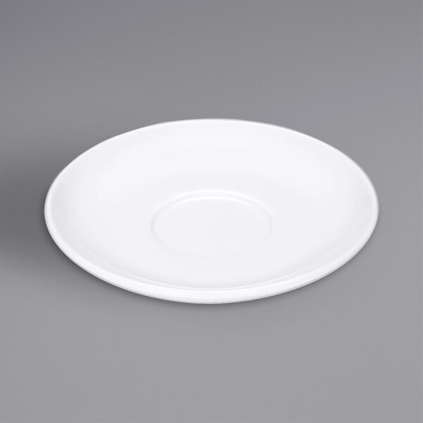 A Bauscher bright white porcelain saucer with a circular shape on a gray surface.