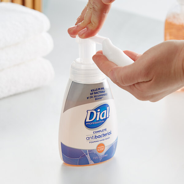 A person using Dial foaming hand soap.