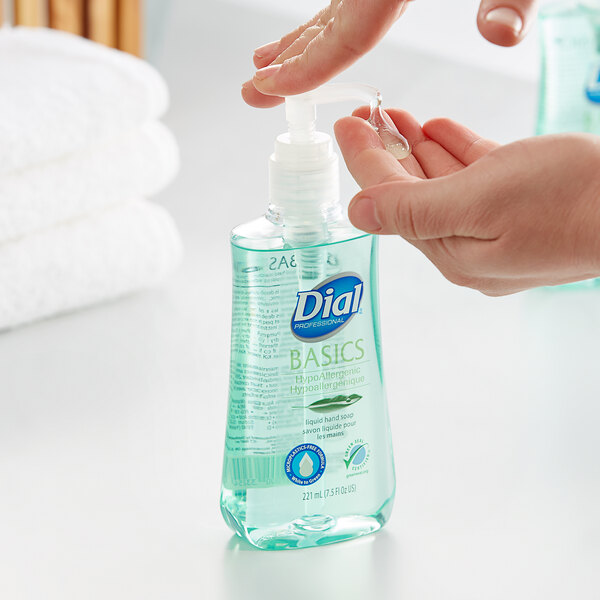 A hand using a pump of Dial Hypoallergenic Liquid Hand Soap over a sink.