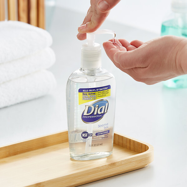 A person using Dial Sensitive Skin liquid hand soap in a soap dispenser.
