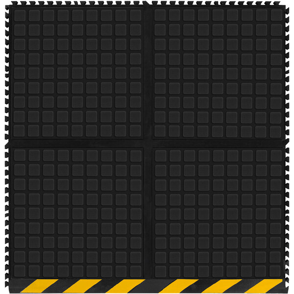 A black square M+A Matting anti-fatigue side tile with yellow striped border.