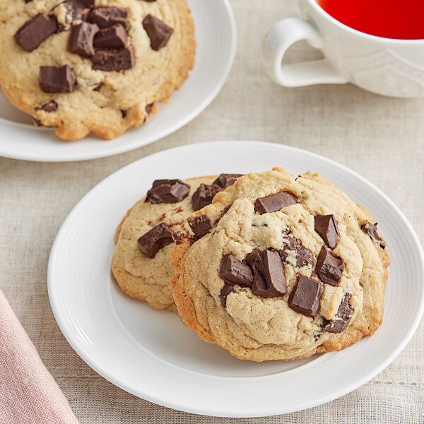 A white plate of chocolate chunk cookies with Van Leer Breda dark chocolate chunks.