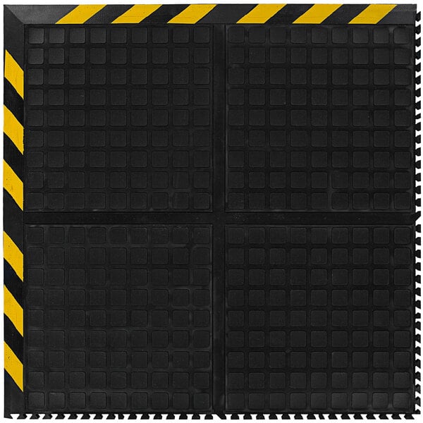 A black and yellow square M+A Matting anti-fatigue mat with black striped border.
