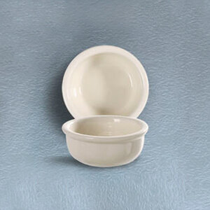 A CAC white china bowl on a blue surface.