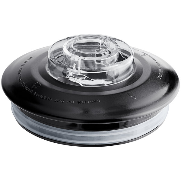 A black and clear plastic lid on a clear glass container with a round bottom.