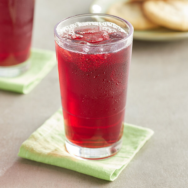 A glass of Old Orchard Cranberry fruit juice on a napkin.