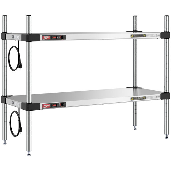 A Metro stainless steel heated countertop shelf with two shelves, black wires, and metal legs.