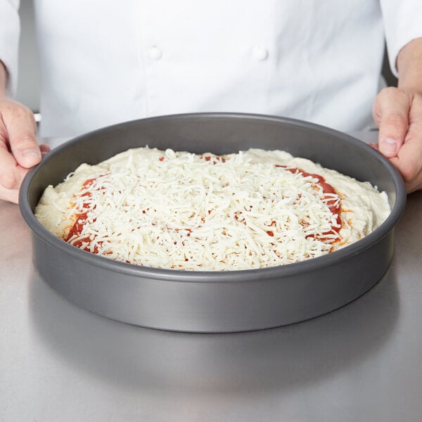 An American Metalcraft hard coat anodized aluminum pan with a pizza in it.