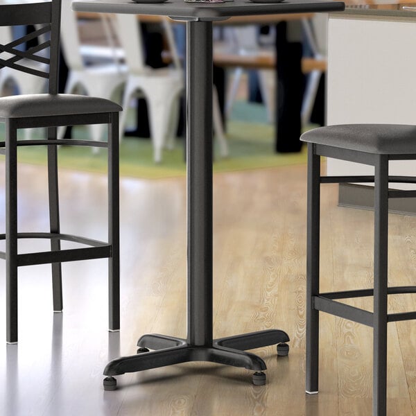 A black Lancaster Table & Seating bar height table base.
