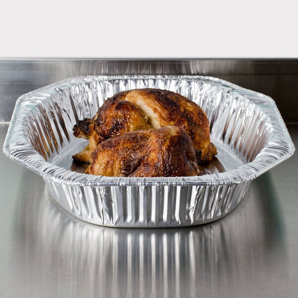 A cooked chicken in a Durable Packaging oval foil roast pan.