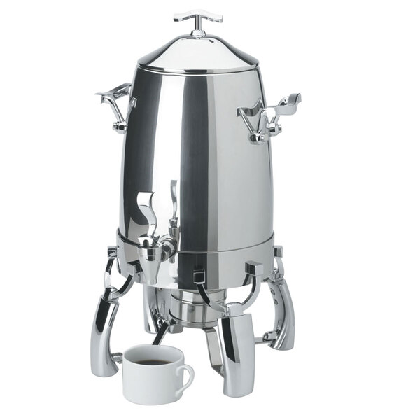 A stainless steel Vollrath Somerville coffee urn with a cup of coffee on top.