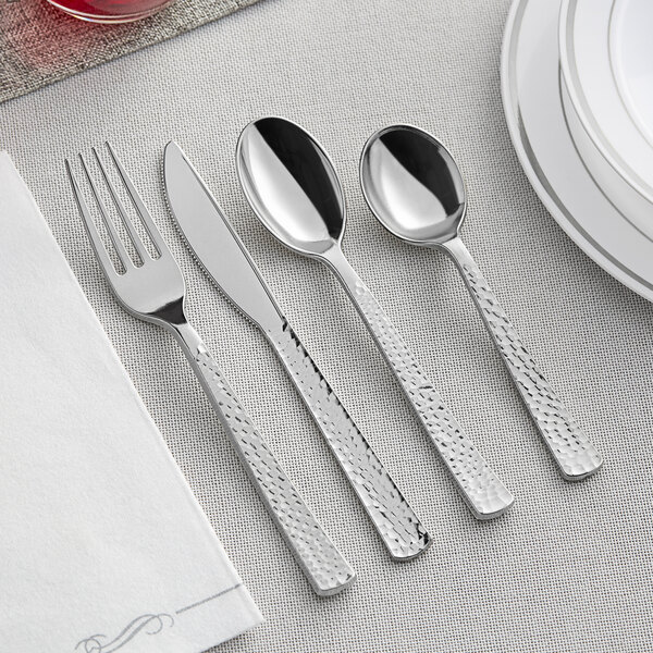 A Visions silverware set on a table with a spoon and fork on a white napkin.