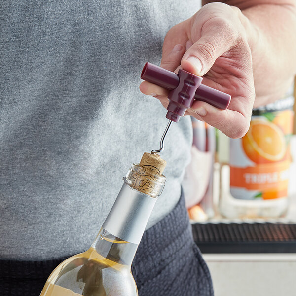 A person using a Choice Burgundy plastic corkscrew to open a bottle of wine with a cork.