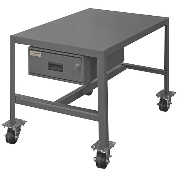 A grey metal Durham machine table with a drawer and wheels.