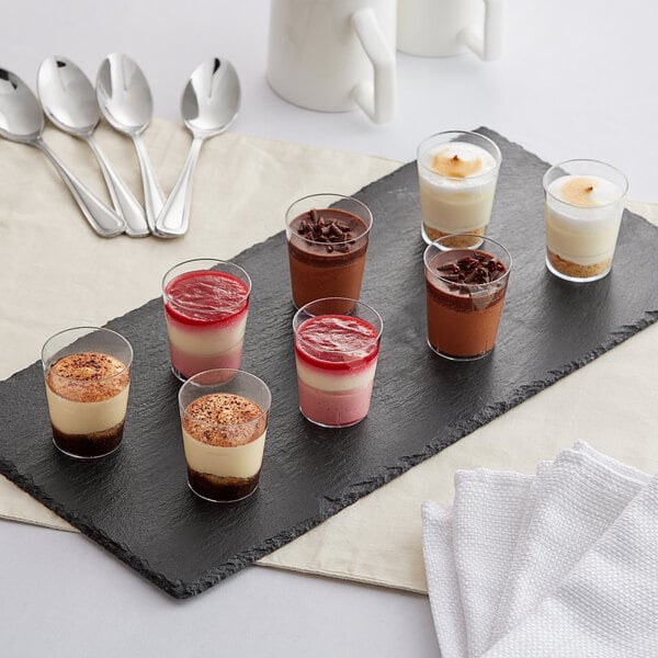 A black tray with White Toque mini assorted desserts including chocolate, white, and red desserts.