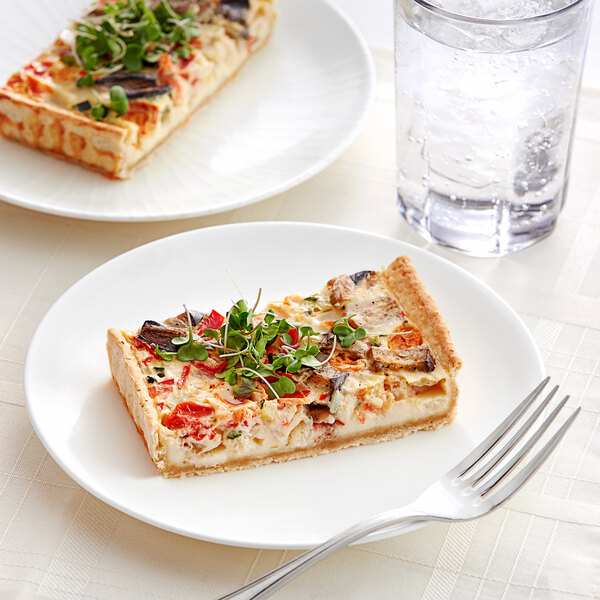 A slice of White Toque Mediterranean Quiche on a plate with a fork.