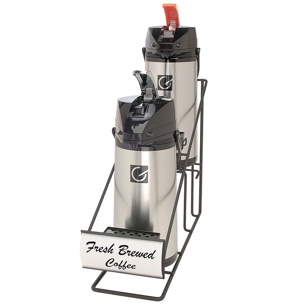 A Grindmaster inline airpot rack with two glass lined airpots on a counter with a coffee dispenser sign.