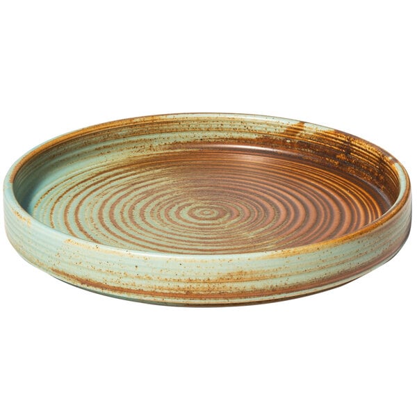 A teal porcelain plate with a brown and green spiral design.