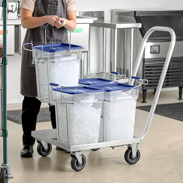 A woman using a Vigor aluminum dolly to transport ice in square containers.
