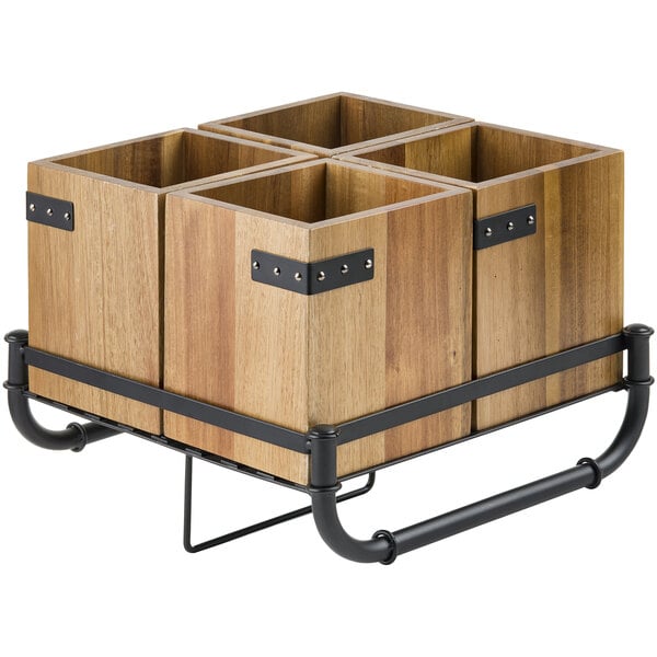A wood container with a black metal frame holding four wooden flatware holders.