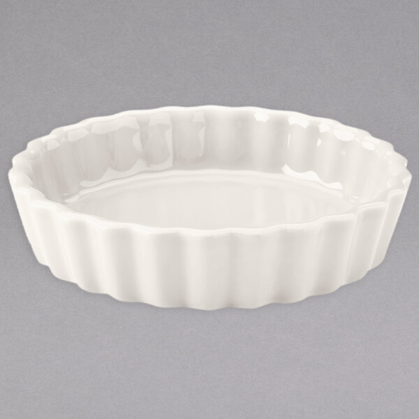 A white ceramic fluted bowl with a scalloped edge.