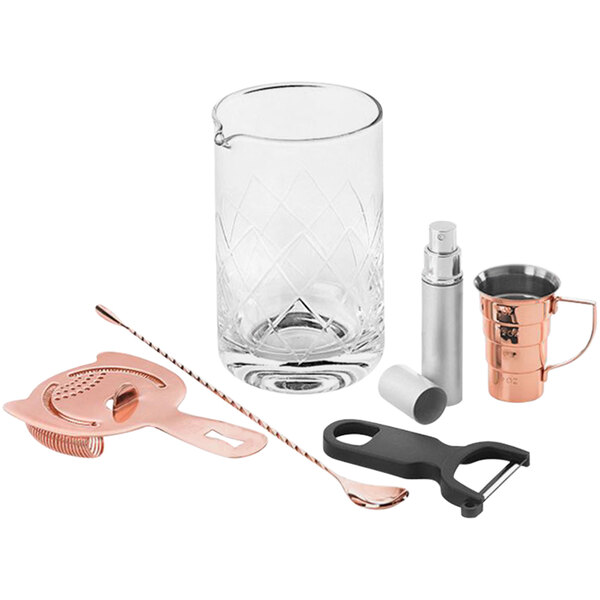 A Barfly copper-plated cocktail shaker, glass, and bottle opener on a table.