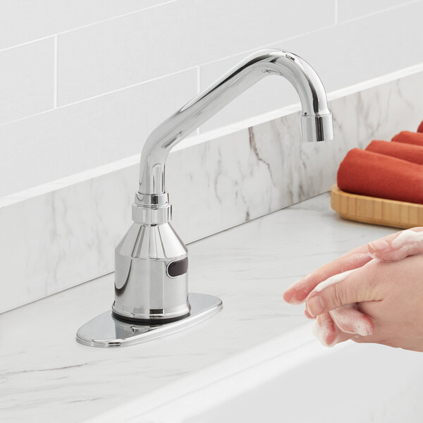 A person using a Waterloo Deck Mount hands-free sensor faucet to wash their hands.